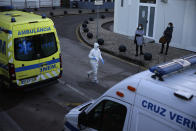 FILE - In this Jan. 18, 2021, file photo, healthcare worker in a protective suit walks among ambulances parked outside the COVID-19 emergency ward at the Santa Maria hospital in Lisbon. In its fight against COVID-19, Portugal lifted restrictions on gatherings and movements for four days over Christmas so that people could spend the festive season with family and friends. Soon after the holiday, the pandemic quickly got out of hand. (AP Photo/Armando Franca File)