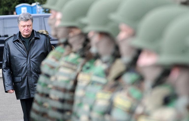 Ukrainian President Petro Poroshenko (L) walks past Ukrainian soldiers before the opening ceremony of the joint Ukraine-US military exercise at the Yavoriv training ground in the western region of Lviv on April 20, 2015