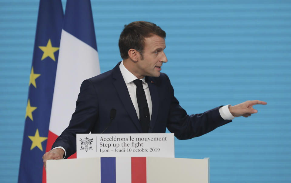 France's President Emmanuel Macron gestures as he delivers a speech at the Lyon's congress hall, central France, Thursday, Oct. 10, 2019, during the meeting of international lawmakers, health leaders and people affected by HIV, Tuberculosis and malaria. Lyon is hosting the two day Global Fund event aimed at raising money to help in the global fight against the epidemics. (AP Photo/Laurent Cipriani)