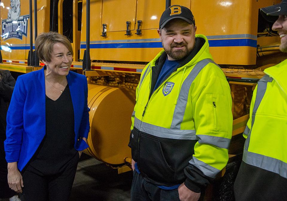 Gov. Maura Healey speaks with Framingham Highway Department lead driver Joe Pineau, center, and Sanitation Operations Manager Darren Guertin before a press conference inside the Framingham DPW headquarters, Jan. 11, 2023.