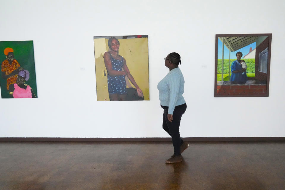 Fadzai Muchemwa, National Art Gallery curator, walks by some of the art works on display by female artists that have been on show at the southern African country's national gallery since International Women's Day on March 8, in Harare, Friday, April, 14, 2023. The exhibition is titled "We Should All Be Human" and is a homage to women's ambitions and their victories, Muchemwa said. (AP Photo/Tsvangirayi Mukwazhi)