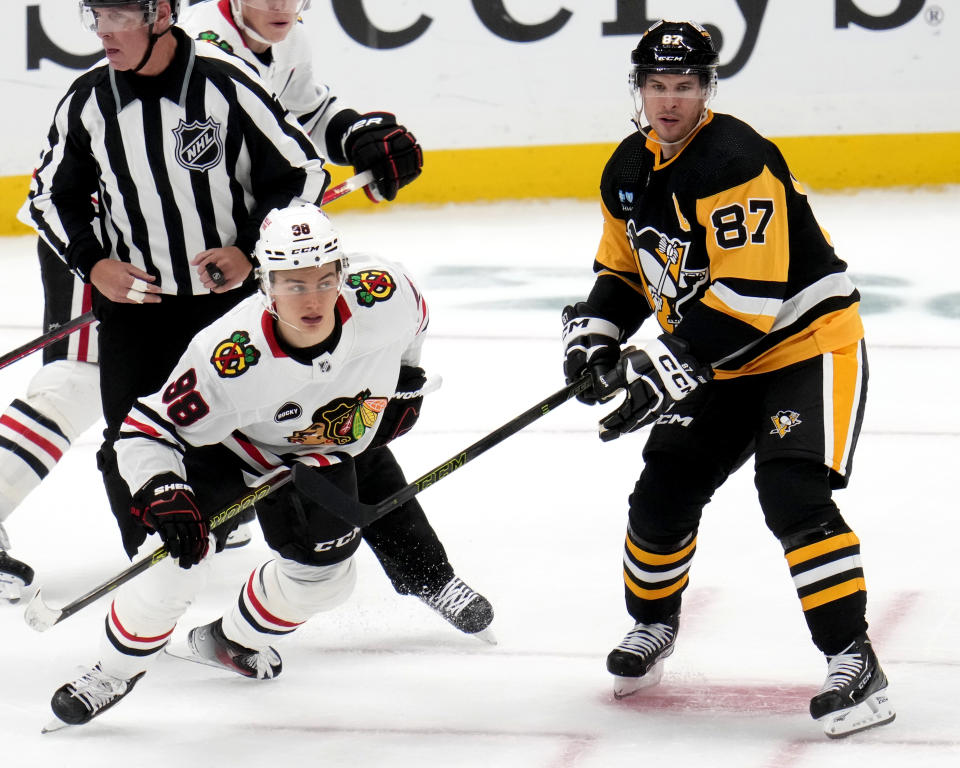 Chicago Blackhawks' Connor Bedard (98) and Pittsburgh Penguins' Sidney Crosby (87) skate during the third period of an NHL hockey game in Pittsburgh, Tuesday, Oct. 10, 2023. (AP Photo/Gene J. Puskar)