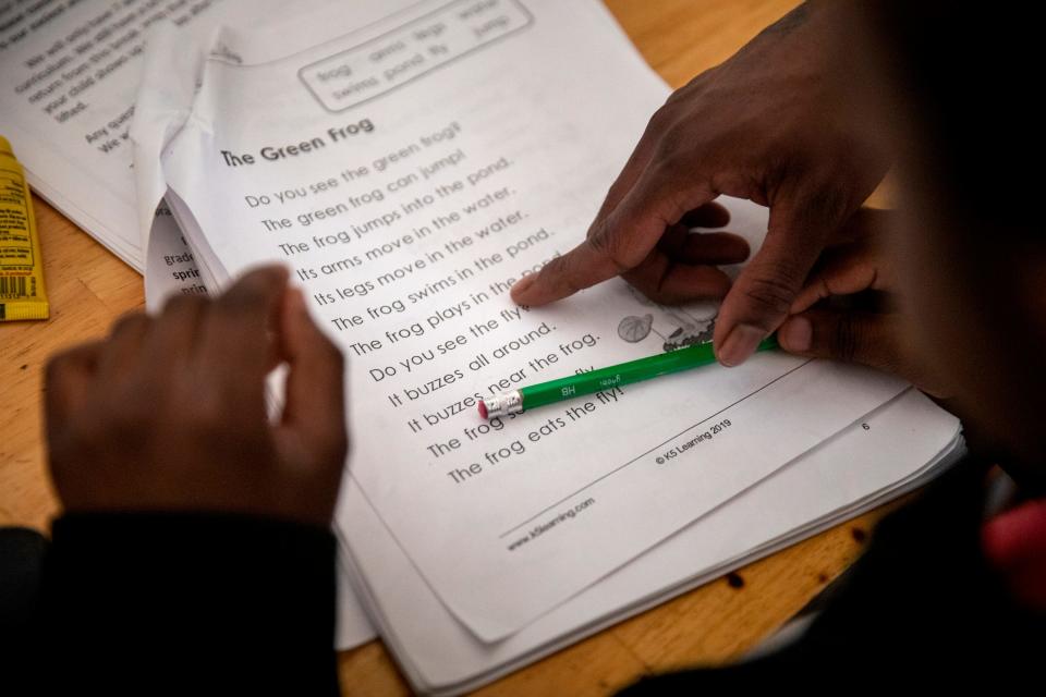 Renee Oliver helps her son Sinaca Wagoner, Jr. 7, with his school work in their apartment in Lower Price Hill on Thursday, April 2, 2020. Sinaca Jr. is in the second grade at Cincinnati College Preparatory Academy. 