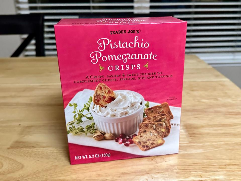 pink box of pistachio pomegranate crisps from trader joe's on wood table