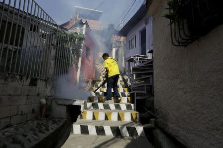 A municipal worker fumigates the Petare slum to help control the spread of the mosquito-borne Zika virus in Caracas, February 3, 2016. REUTERS/Marco Bello