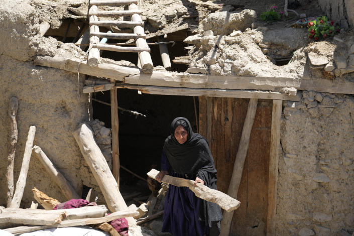 Afghan woman cleans up after an earthquake in Gayan village, in Paktika province, Afghanistan, Friday June 24, 2022. A powerful earthquake struck a rugged, mountainous region of eastern Afghanistan early Wednesday, flattening stone and mud-brick homes in the country's deadliest quake in two decades, the state-run news agency reported. (AP Photo/Ebrahim Nooroozi)
