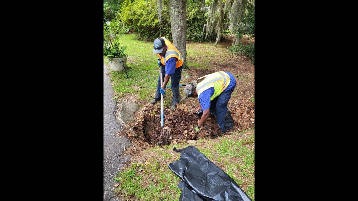 Workers with Beaufort Public Works remove debris blocking driveway pipes in advance of Hurricane Ian.