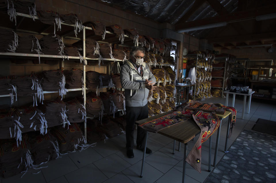 Tailor Karl Kersten stands in his atelier with shelves full of costumes for the Gilles de Binche in Binche, Belgium, Thursday, Feb. 11, 2021. The economic impact of the cancellation of this years carnival due to COVID-19 will be difficult for local craftspersons who rely on the income. Kersten, a fourth-generation tailor of Gilles de Binche costumes, spends all year preparing for the event and rents about 1,000 costumes. This year his shelves are full. (AP Photo/Virginia Mayo)