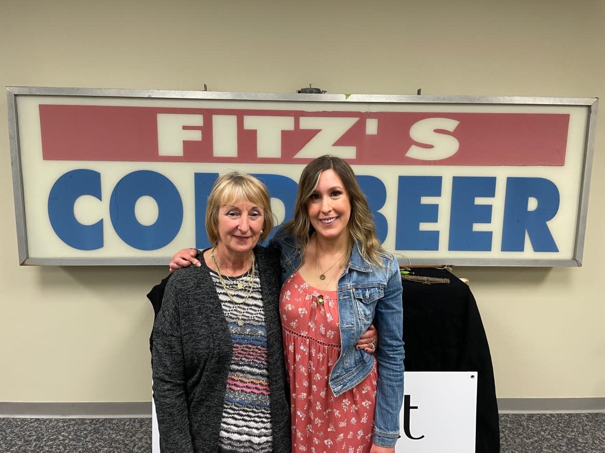 Christine Fitzpatrick, left, and her daughter Angie decided to auction off this sign in honour of their late husband and father, John Fitzpatrick. (Ryan Cooke/CBC - image credit)