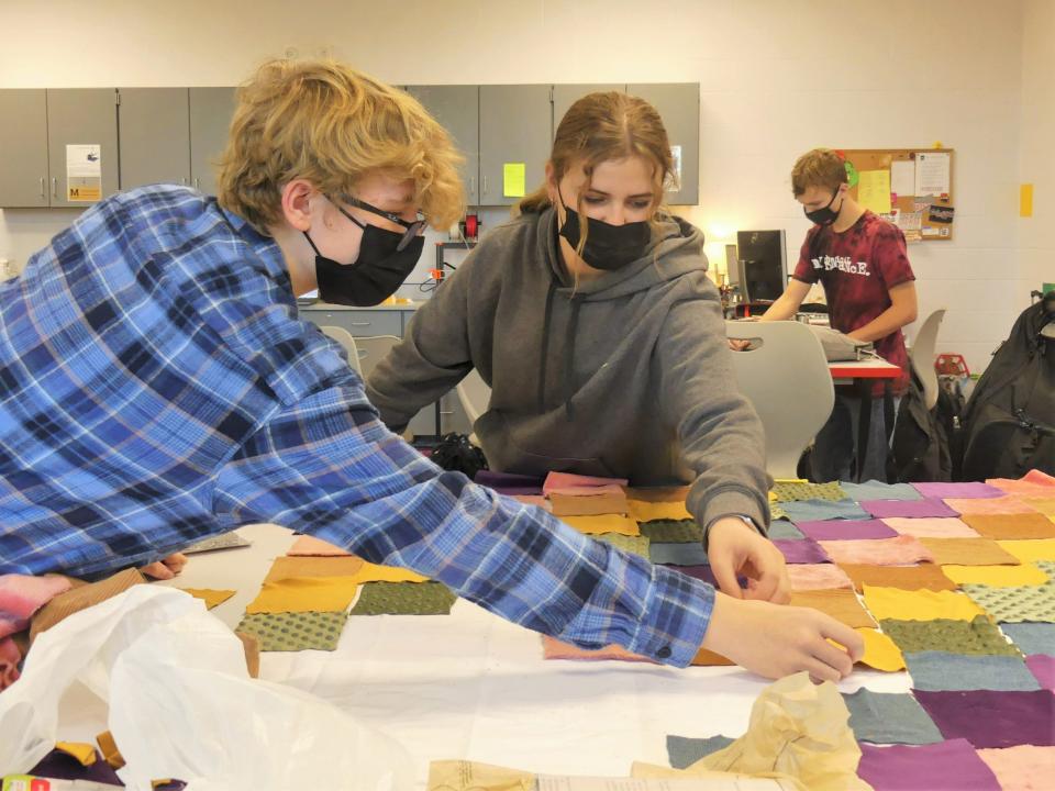 Gabriel Campbell and Ava Norton, eighth graders at Edgewood Junior High School, lay out squares of fabric Nov. 18 in the school's design lab.
