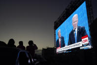 People watch from their vehicle as President Donald Trump, on left of video screen, and Democratic presidential candidate former Vice President Joe Biden speak during a Presidential Debate Watch Party at Fort Mason Center in San Francisco, Thursday, Oct. 22, 2020. The debate party was organized by Manny's, a San Francisco community meeting and learning place. (AP Photo/Jeff Chiu)