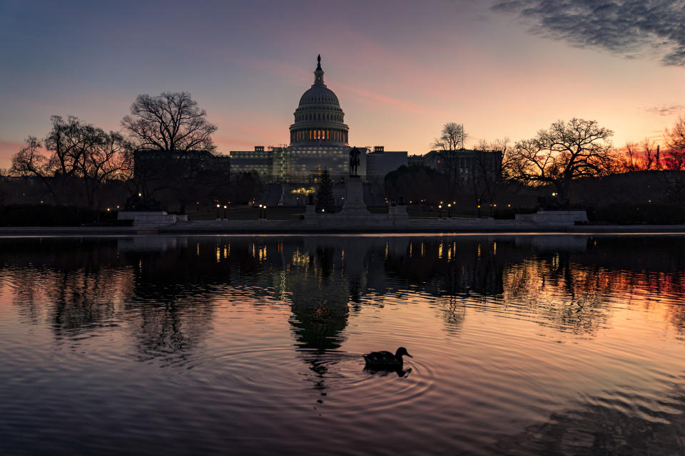 FILE - The sun rises behind the Capitol in Washington, early Wednesday, Dec. 14, 2022. Congressional leaders have unveiled a $1.7 trillion spending package early Tuesday, Dec. 20, 2022, that includes another large round of aid to Ukraine, a nearly 10% boost in defense spending and roughly $40 billon to assist communities across the country recovering from drought, hurricanes and other natural disasters. (AP Photo/J. Scott Applewhite, File)