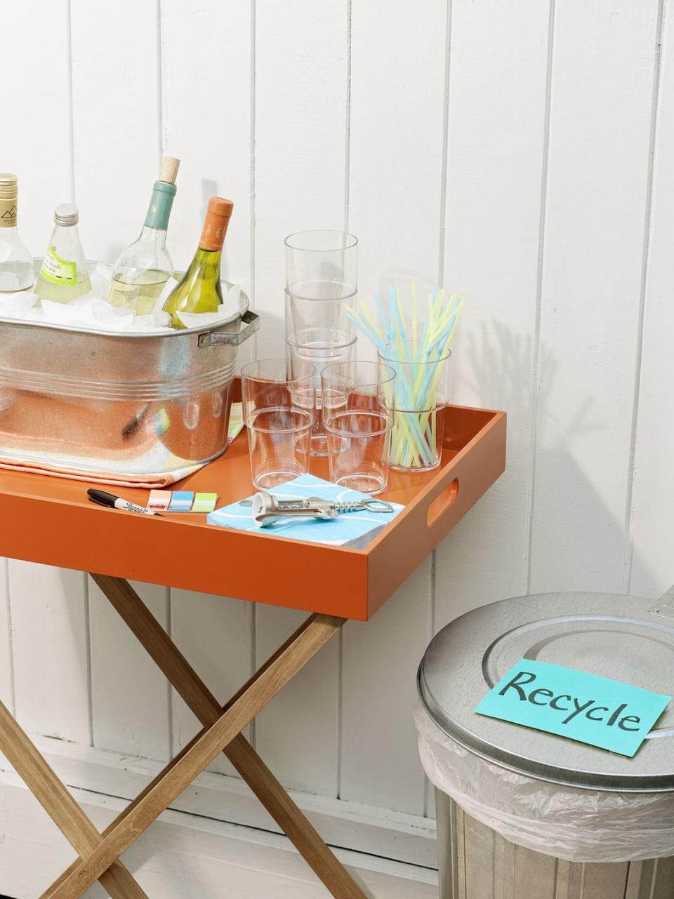 <p>A beverage station separate from the food lets guests mix drinks and mingle. Stock the bar with cups, straws (to double as stirrers) and plenty of ice — a large metal pail will keep bottles and cans frosty, but consider an insulated cooler for extra cubes. </p>