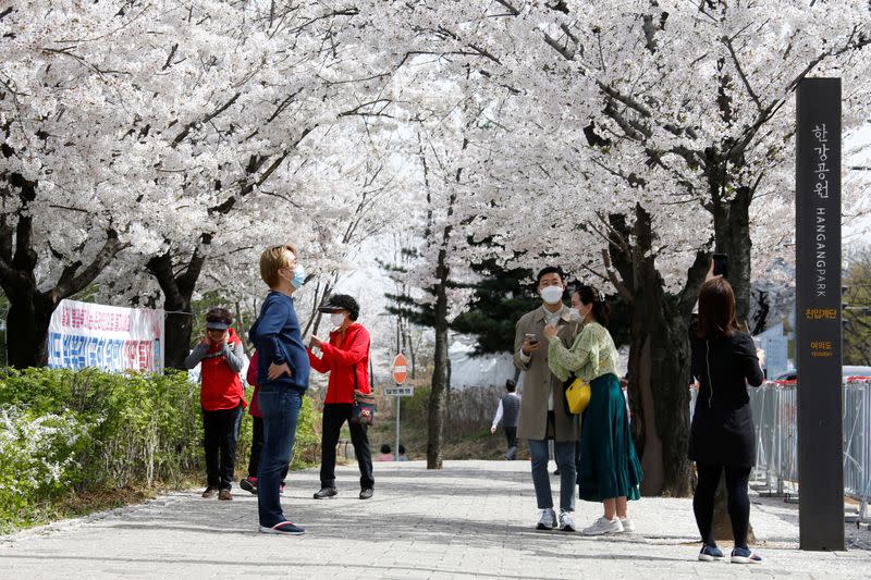 FILE PHOTO: People walk near a cherry blossom street, closed to avoid the spread of the COVID-19, in Seoul