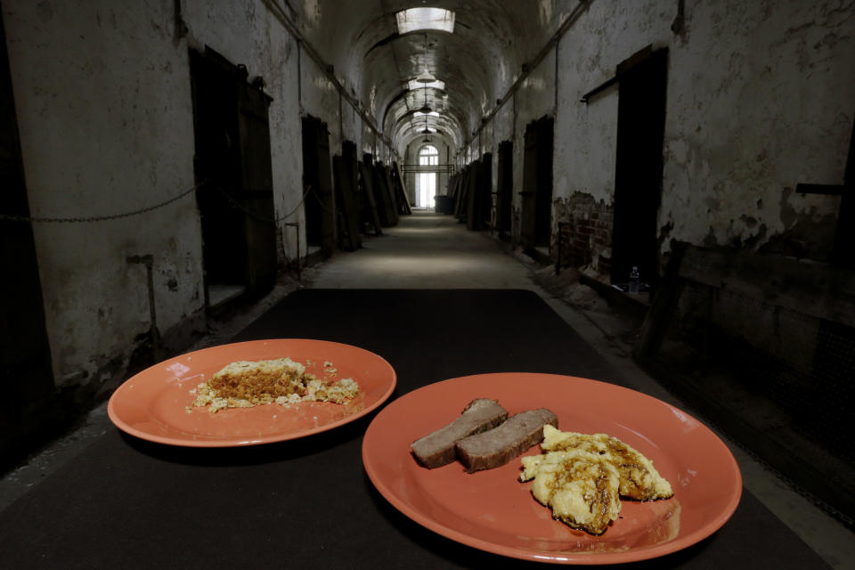 In this Friday, May 31, 2013 photo displayed are plates of prison food at Eastern State Penitentiary in Philadelphia. On left, Nutraloaf, presently served in Pennsylvania prisons as a “behavior modified meal” and salt beef, with “Indian Mush,” an inmate dinner from the 1800s. The historic penitentiary plans to serve visitors sample meals from the 1800s, 1900s and today on June 8th and 9th. (AP Photo/Matt Rourke)