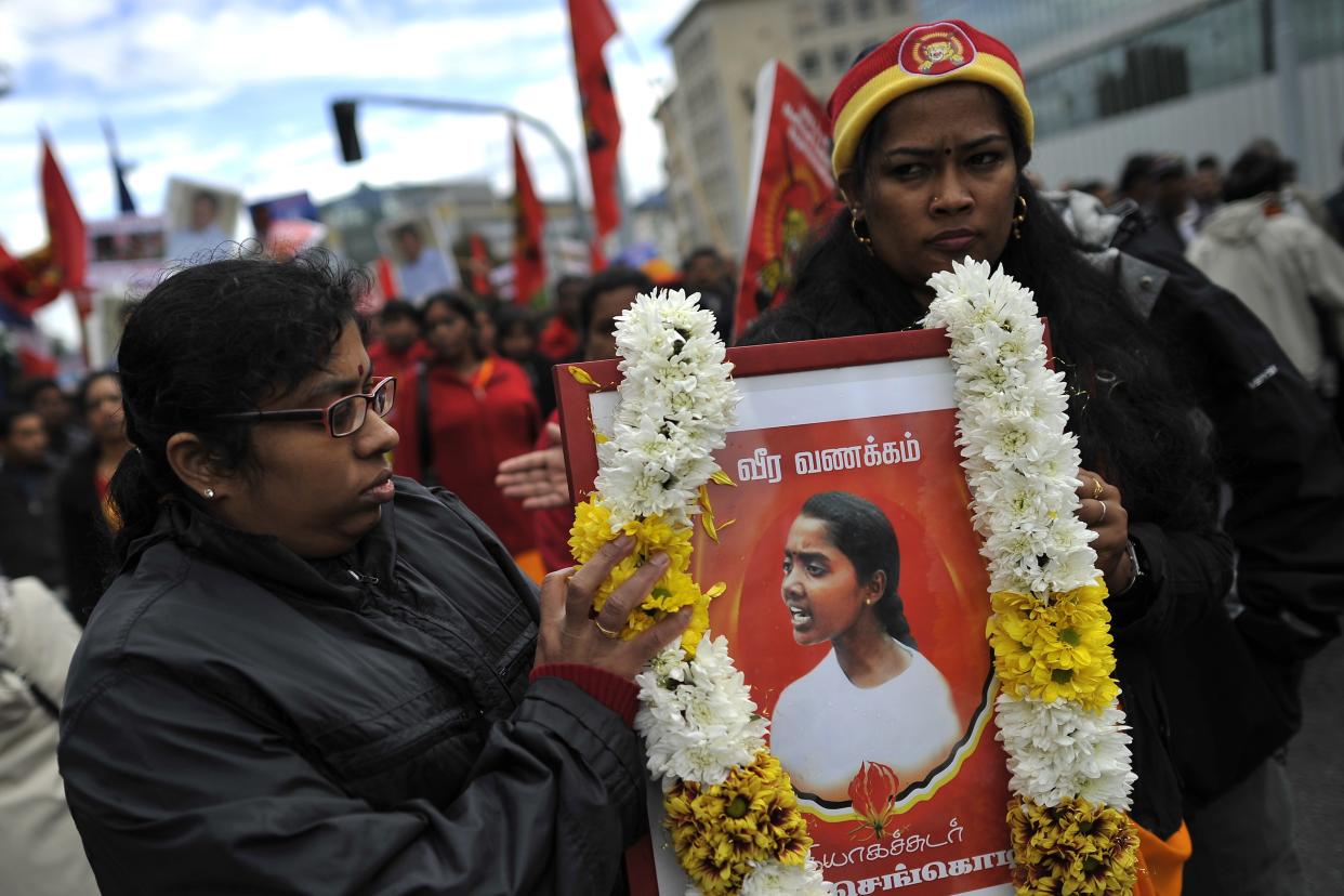 <p>Two women hold a portrait of a casualty of war during a demonstration on September 19, 2011 at the UN's European headquarters in Geneva calling for a probe into alleged war crimes committed by Sri Lanka </p> (AFP via Getty Images)