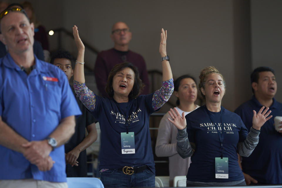 Congregants dance and pray with the church band before Pastor Andy Wood gives a sermon on Sunday, Oct. 16, 2022, at Saddleback Church in Lake Forest, Calif. Wood was recently announced as founding Pastor Rick Warren's successor to the church, which is the second largest in the Southern Baptist Convention, regularly drawing in about 2,500 people with more online every Sunday. (AP Photo/Allison Dinner)