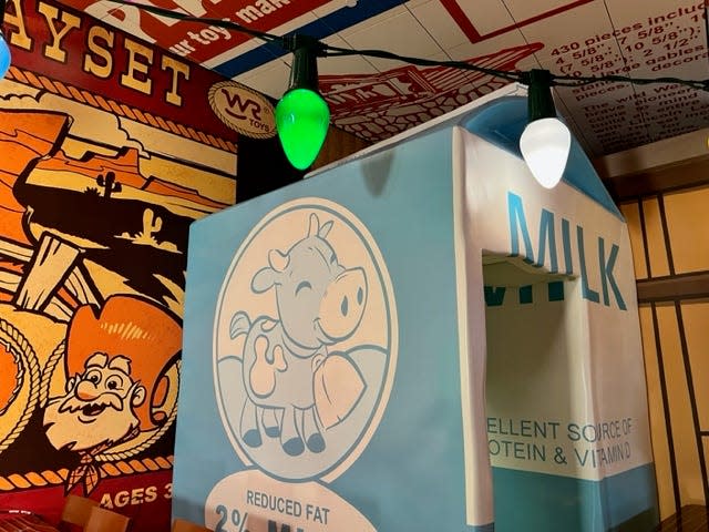Disney Imagineer Jared Sell encourages guests to look around massive milk carton for fun details.
