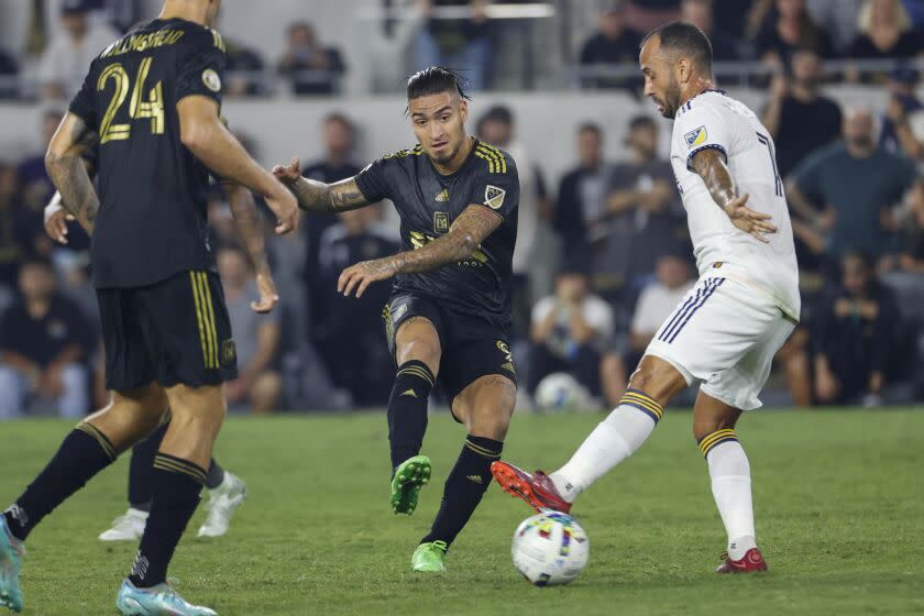 Los Angeles FC forward Cristian Arango (9) passes the ball against LA Galaxy midfielder Victor Vazquez (7) during the second half of an MLS playoff soccer match on Thursday, Oct. 20, 2022, in Los Angeles. Los Angeles FC won 3-2. (AP Photo/Ringo H.W. Chiu)