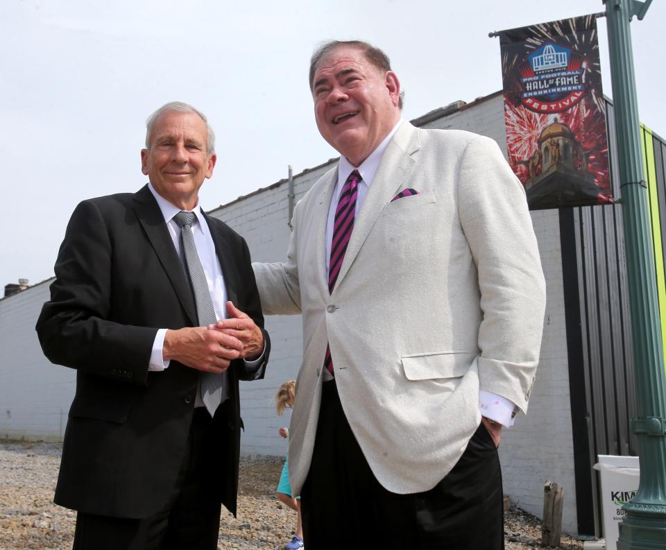 Canton Mayor Thomas M. Bernabei, left, speaks with David Baker, president and CEO of the Pro Football Hall of Fame, prior to the unveiling of the "1958 Championship Game," statue in Canton on Friday, August 6, 2021. It is the final piece in "The ELEVEN," which are 11 football-themed art pieces located throughout Canton. 