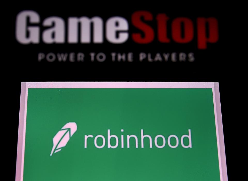 This photo illustration shows the logos of video grame retail store GameStop and trading application Robinhood in a computer and on a mobile phone in Arlington, Virginia on January 28, 2021. - An epic battle is unfolding on Wall Street, with a cast of characters clashing over the fate of GameStop, a struggling chain of video game retail stores. The conflict has sent GameStop on a stomach-churning ride with amateur investors taking on the financial establishment in the mindset of the Occupy Wall Street movement launched a decade ago. (Photo by Olivier DOULIERY / AFP) (Photo by OLIVIER DOULIERY/AFP via Getty Images)