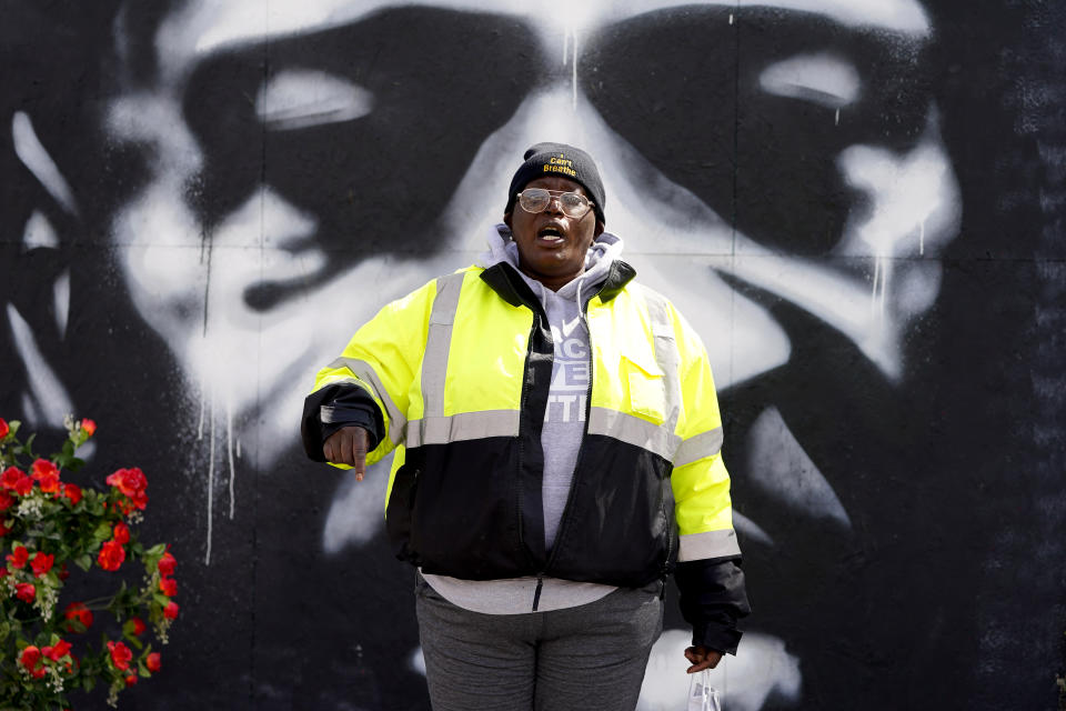 An organizer speaks in front of a mural depicting George Floyd's likeness at George Floyd Square, Wednesday, April 21, 2021, in Minneapolis, a day after former Minneapolis police Officer Derek Chauvin was convicted on all counts for the 2020 death of Floyd. (AP Photo/Julio Cortez)