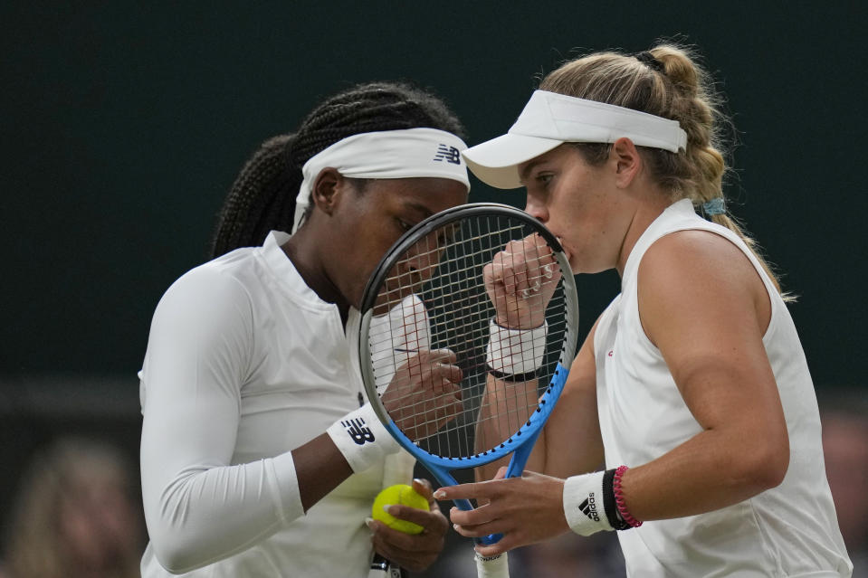 Coco Gauff of the U.S., left, and compatriot Caty McNally speak during the women's doubles third round match against Russia's Veronika Kudermetova and Elena Vesnina on day eight of the Wimbledon Tennis Championships in London, Tuesday, July 6, 2021. (AP Photo/Kirsty Wigglesworth)