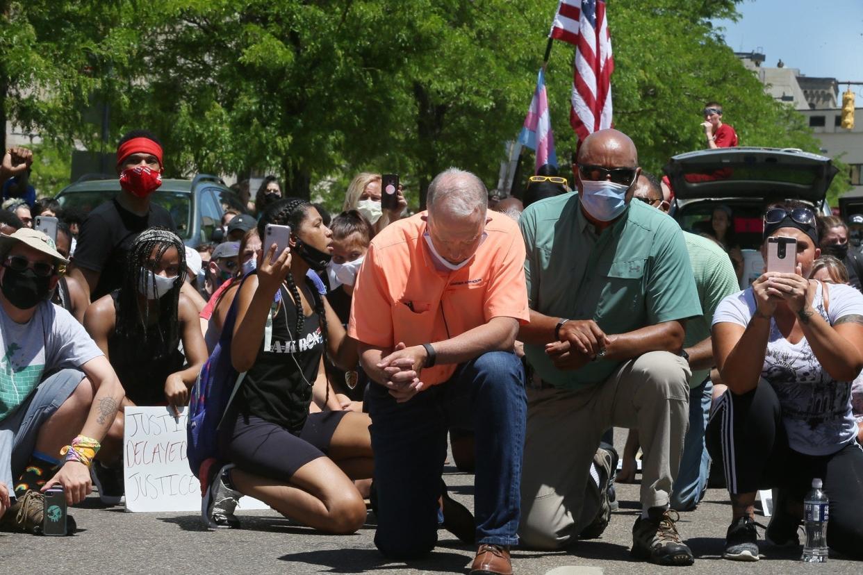 Akron Mayor Dan Horrigan and Charles Brown, deputy mayor for public safety, kneel with protesters June 6 on South High Street during demonstrations over the police killing of George Floyd in Minneapolis.