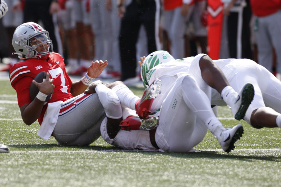 Ohio State quarterback C.J. Stroud, left, is sacked by Oregon defensive end DJ Johnson, center, and defensive lineman Brandon Dorlus on the final play of the game in the second half of an NCAA college football game Saturday, Sept. 11, 2021, in Columbus, Ohio. Oregon beat Ohio State 35-28. (AP Photo/Jay LaPrete)