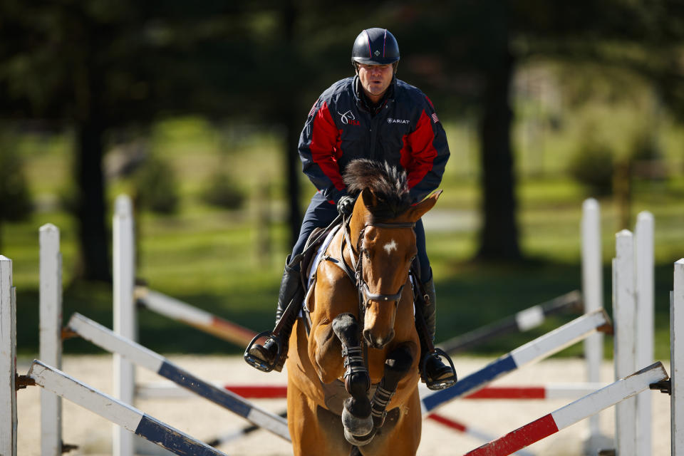 FILE - Phillip Dutton rides Z through a series of jumps while training at his farm in West Grove, Pa., in this Thursday, April 2, 2020, file photo. The roster released by the U.S. Olympic and Paralympic Committee for the Tokyo Games includes 329 women and 284 men. Swimmer Katie Grimes is the youngest U.S. Olympian at 15, while equestrian Phillip Dutton is the oldest at 57. (AP Photo/Matt Slocum, File)