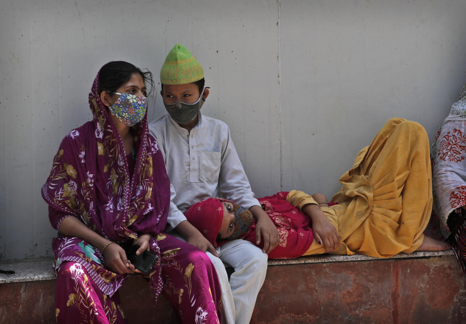 A family waits to receive the body of a person who died due to COVID-19 outside a mortuary, in New Delhi, India, Monday, April 19, 2021. India's health system is collapsing under the worst surge in coronavirus infections that it has seen so far. (AP Photo/Manish Swarup)