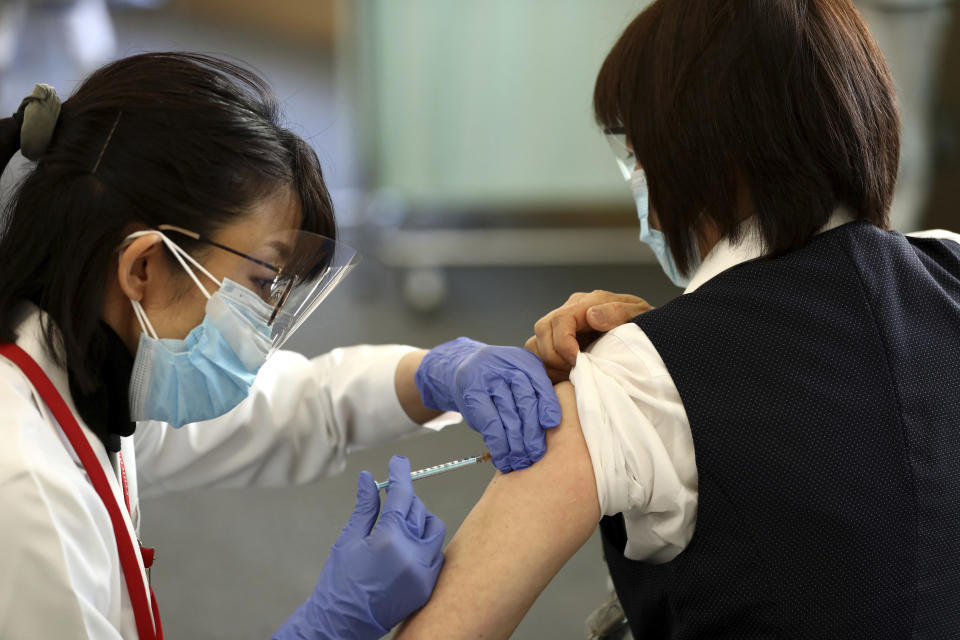 A medical worker receives a dose of COVID-19 vaccine Tokyo Medical Center in Tokyo Wednesday, Feb. 17, 2021. Japan's first coronavirus shots were given to health workers Wednesday, beginning a vaccination campaign considered crucial to holding the already delayed Tokyo Olympics. (Behrouz Mehri/Pool Photo via AP)