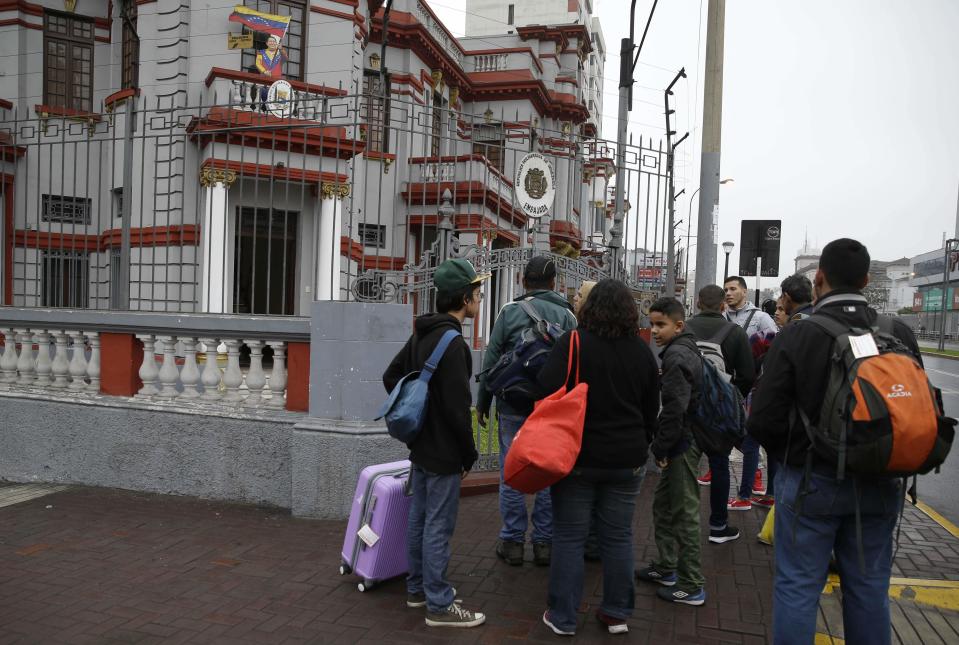 Venezuelan migrants wait outside their country's embassy for a bus that will transport them to the airport, in Lima, Peru, Monday, Aug. 27, 2018. The Venezuelans are being flown to Caracas on a flight financed by the government of President Nicolas Maduro. (AP Photo/Martin Mejia)