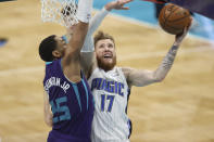 Orlando Magic forward Ignas Brazdeikis, right, shoots against Charlotte Hornets forward P.J. Washington during the second half of an NBA basketball game in Charlotte, N.C., Friday, May 7, 2021. (AP Photo/Nell Redmond)