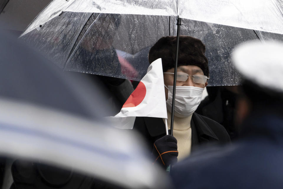 A well-wisher holds a Japanese national flag as he arrives for the appearance of Japan's Emperor Naruhito for his birthday at the Imperial Palace in Tokyo on Friday, Feb. 23, 2024. Emperor Naruhito turns 64 on Friday. (Tomohiro Ohsumi/Pool Photo via AP)