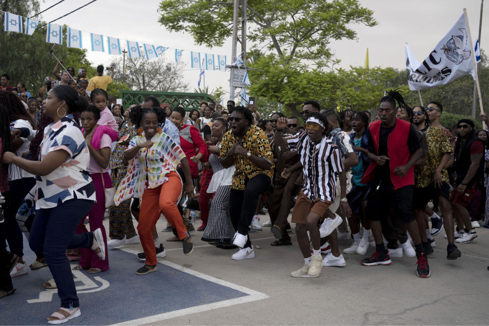 Members of the African Hebrew Israelites of Jerusalem community dance during a procession past their elders and community leaders during New World Passover celebrations marking the group's exodus from the United States, in Dimona, Israel, Friday, June 2, 2023. The community observes an interpretation of biblical laws formulated by their late founder that includes strict veganism, abstention from tobacco and hard alcohol, fasting on the Sabbath, and a ban on wearing synthetic fabrics. (AP Photo/Maya Alleruzzo)