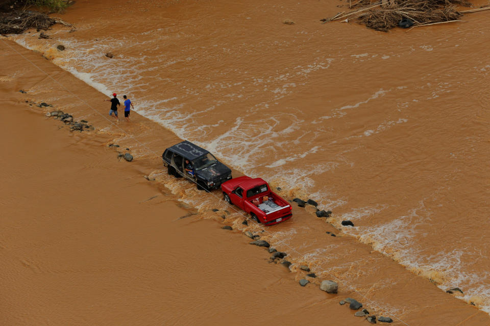 <p>A truck attempts to pull another vehicle across a flood damaged roadway as recovery efforts continue following Hurricane Maria near the village of San Lorenzo, Puerto Rico, Oct. 7, 2017. (Photo: Lucas Jackson/Reuters) </p>