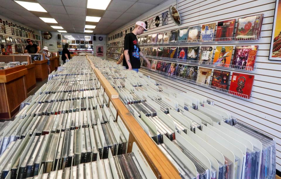 A customer looks over vinyl albums near racks of CDs at Music Boxx Records, Tuesday, August 2, 2022, in Sheboygan, Wis.