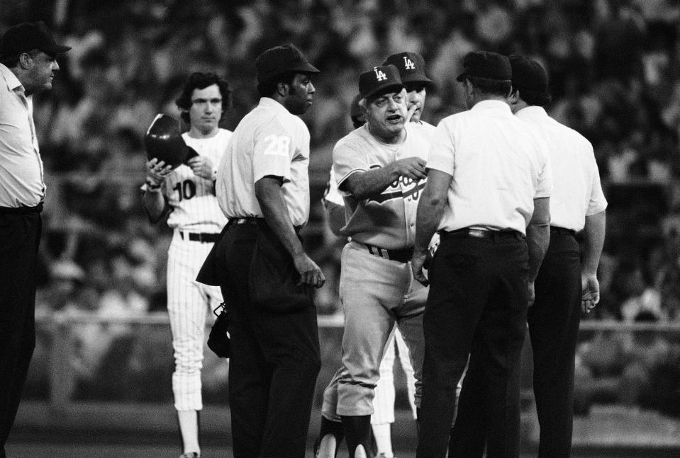 Phillies Larry Bowa stands on first base as he watches Los Angeles Dodgers manager Tom Lasorda argue with the umpires in the third inning of game, Friday, June 3, 1978 (AP Phot/Rusty Kennedy)