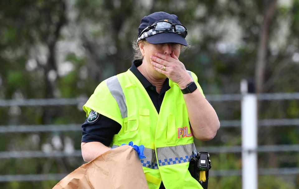 A teary Queensland Police Officer is seen investigating the scene where 53-year-old  Senior Constable David Masters was killed. Source: AAP