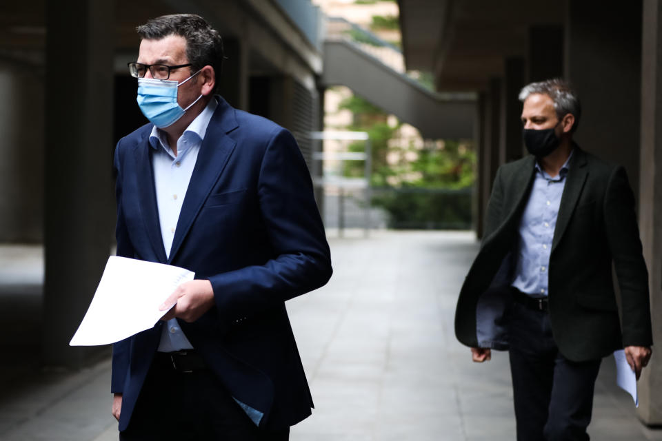 MELBOURNE, AUSTRALIA - AUGUST 17: Premier of Victoria Daniel Andrews (left) and Victorian Chief Health Officer, Brett Sutton (right) arrive for the press conference on August 17, 2021 in Melbourne, Australia. Lockdown restrictions have been extended for another two weeks across Melbourne as Victoria continues to record new cases of the highly infectious COVID-19 Delta variant. A curfew is also now in place from 9 pm to 5 am each night across the metropolitan area. The new restrictions will remain in place until 11.59 pm on Thursday, 2 September. (Photo by Asanka Ratnayake/Getty Images)