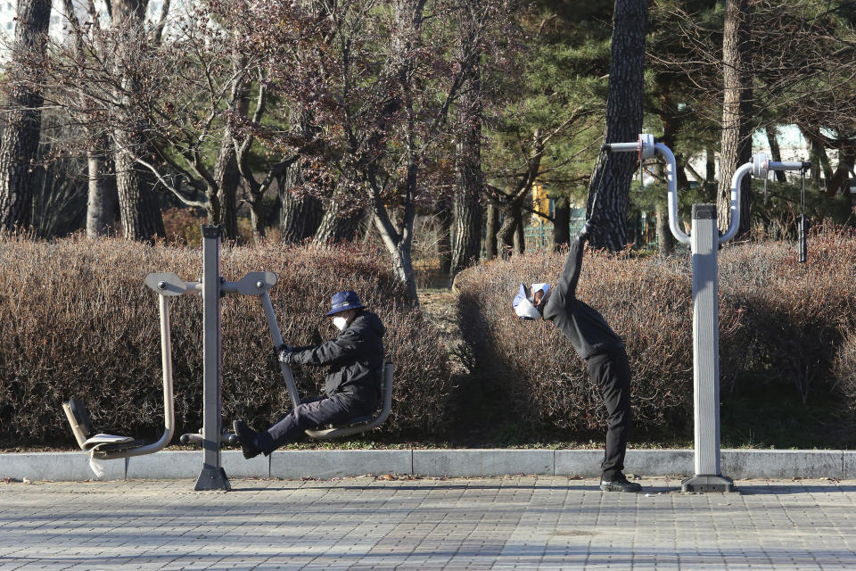 People wearing face masks as a precaution against the coronavirus exercise at a park at a park in Goyang, South Korea, Friday, Dec. 4, 2020. The Korea Disease Control and Prevention Agency said Friday that 600 of the newly confirmed patients were domestically transmitted cases — nearly 80% of them in the densely populous Seoul area, which has been at the center of a recent viral resurgence. (AP Photo/Ahn Young-joon)