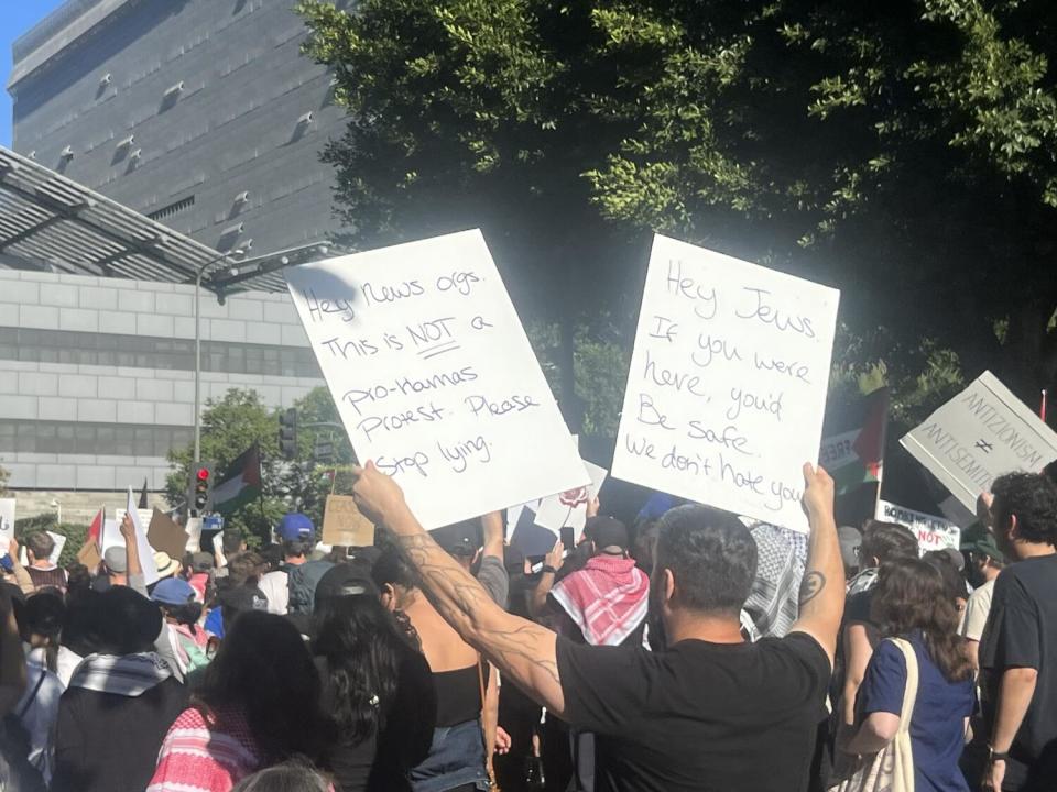 Roy Alnashef, a Palestinian American living in Reseda, holds up his handwritten posters at a recent pro-Palestinian protest.