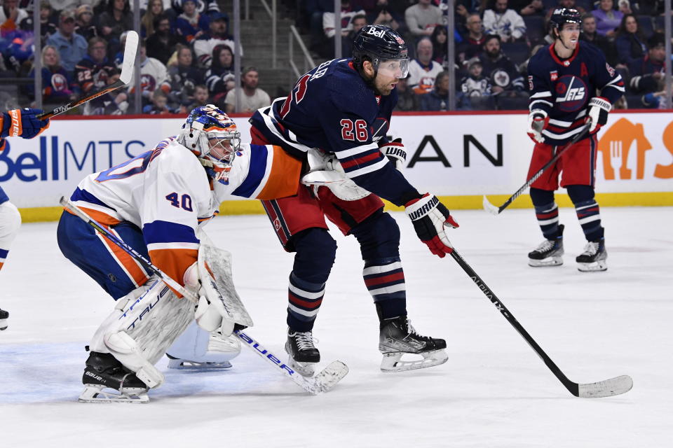 New York Islanders goaltender Semyon Varlamov (40) and Winnipeg Jets' Blake Wheeler (26) position themselves in front of the net during second-period NHL hockey game action in Winnipeg, Manitoba, Sunday, Feb. 26, 2023. (Fred Greenslade/The Canadian Press via AP)