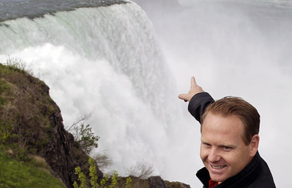 Nik Wallenda points to Niagara Falls after a news conference in Niagara Falls, N.Y., Wednesday, May 2, 2012. Wallenda will try to cross the Niagara Gorge on a tightrope June 15. The seventh-generation member of the Flying Wallendas spent months getting the necessary permissions from Canada and the United States for the cross-border stunt. (AP Photo/David Duprey)