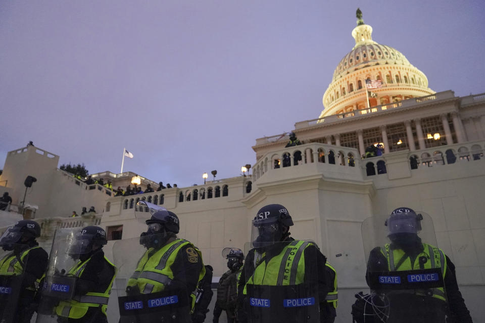 In this Wednesday, Jan. 6, 2021, photo, police form a line to guard the Capitol after violent rioters stormed the Capitol, in Washington. The top watchdog for the U.S. Capitol Police will testify to Congress for the first time about the department’s broad failures before and during the Jan. 6 insurrection. Among them was missed intelligence and old weapons that officers didn’t feel comfortable using. (AP Photo/John Minchillo)