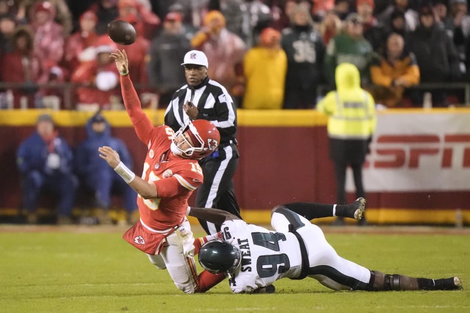 Kansas City Chiefs quarterback Patrick Mahomes, left, throws under pressure from Philadelphia Eagles defensive end Josh Sweat (94) during the second half of an NFL football game, Monday, Nov. 20, 2023, in Kansas City, Mo. Mahomes was charged with intentional grounding on the play. (AP Photo/Charlie Riedel)