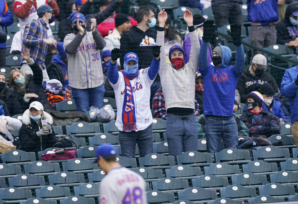 Fans celebrate as New York Mets starting pitcher Jacob deGrom heads to the dugout after striking out Colorado Rockies' C.J. Cron to end the fourth inning of the first baseball game of a doubleheader Saturday, April 17, 2021, in Denver. (AP Photo/David Zalubowski)
