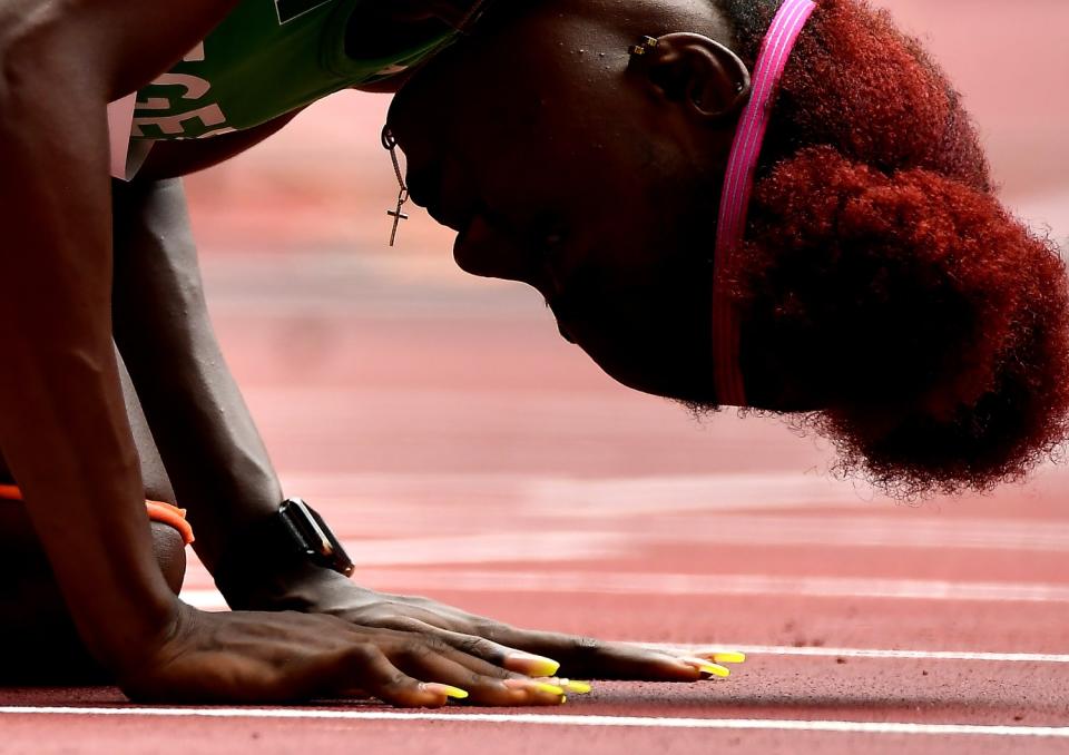 Tobi Amusan of Nigeria kneels before the women's 100-meter hurdles at the Tokyo Olympics.