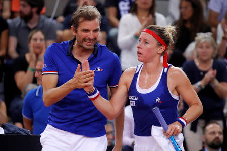 Tennis - Fed Cup - World Group Semi-Final - France v Romania - Kindarena, Rouen, France - April 21, 2019 France's Pauline Parmentier celebrates with captain Julien Benneteau during her match against Romania's Irina-Camelia Begu REUTERS/Charles Platiau